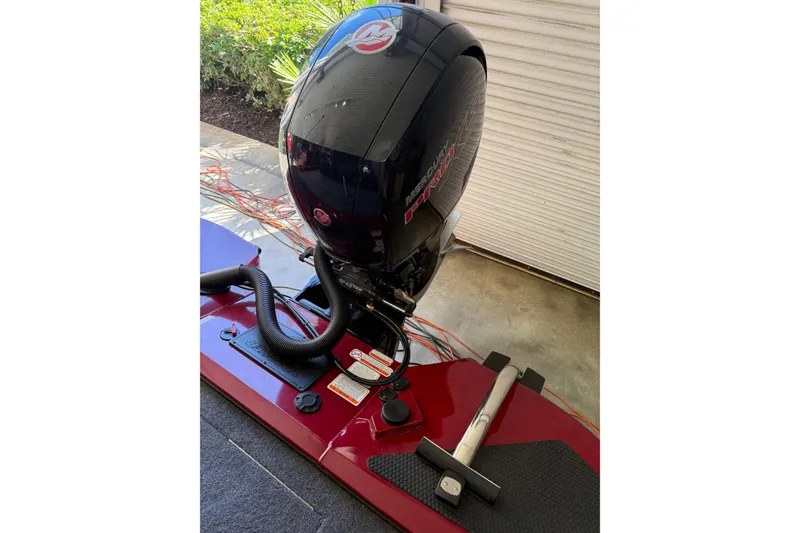 Slide: The Image of 2025 Tracker Savage 215 boat with Mercury Pro XS engine in a garage setting. - 10