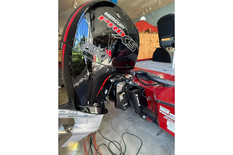 Slide: The Image of 2025 Tracker Savage 215 boat with Mercury Pro XS engine in a garage setting. - 9