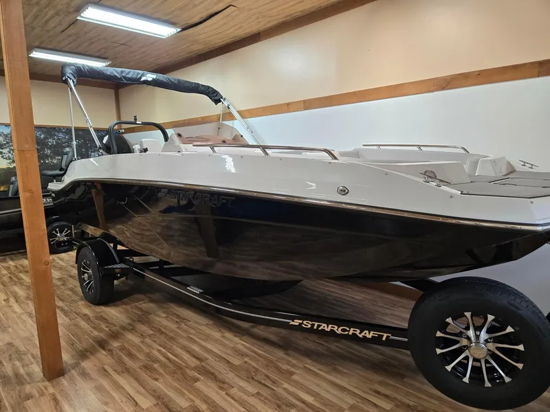 Slide: The Image of 2025 Starcraft SVX211OB boat on trailer in showroom with wood flooring. - 1
