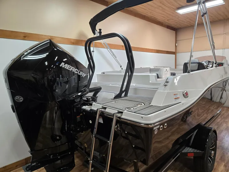 Slide: The Image of 2025 Starcraft SVX211OB boat with Mercury outboard motor in indoor showroom. - 2