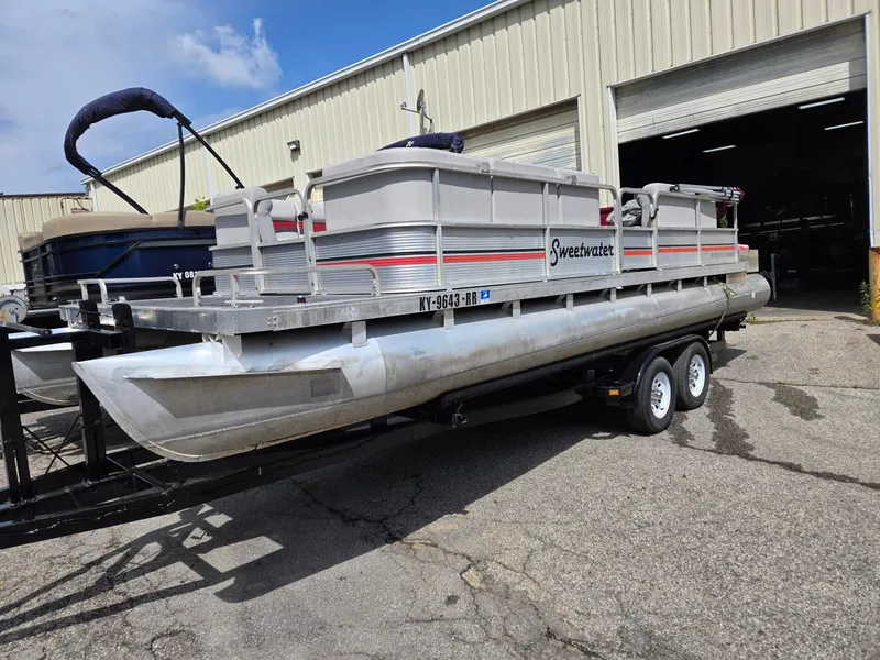 Slide: The Image of 1988 Sweetwater Executive Cruiser pontoon boat on trailer outside a warehouse. - 3