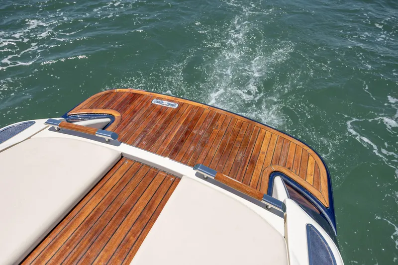 Slide: The Image of 2022 Chris-Craft Launch 27 boat with elegant wooden deck on water. - 11