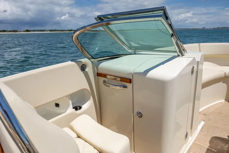 Slide: The Image of 2022 Chris-Craft Launch 27 boat interior with open windshield, on a sunny day at sea. - 14