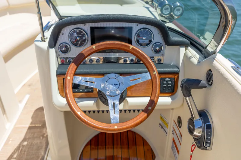 Slide: The Image of 2022 Chris-Craft Launch 27 dashboard with wooden steering wheel and modern controls. - 16