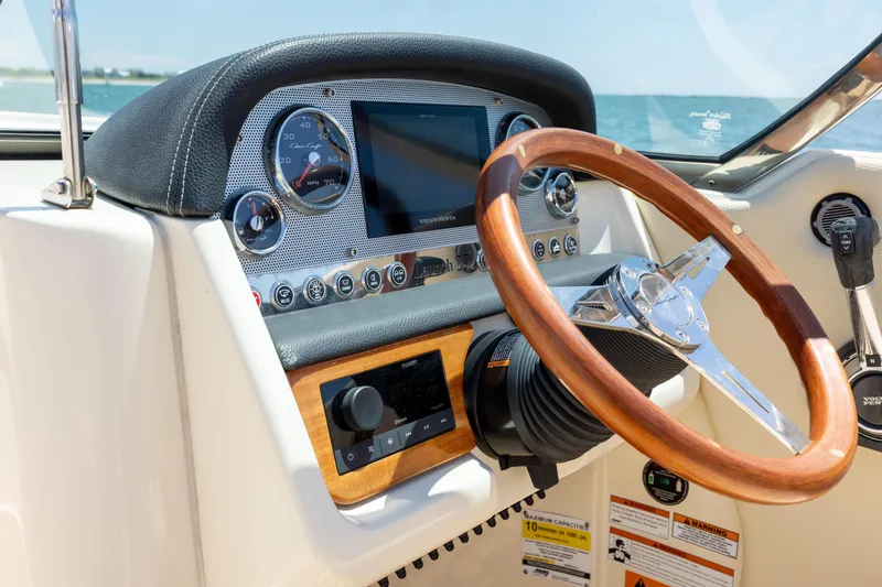 Slide: The Image of Dashboard of 2022 Chris-Craft Launch 27 boat with wooden steering wheel and modern controls. - 17