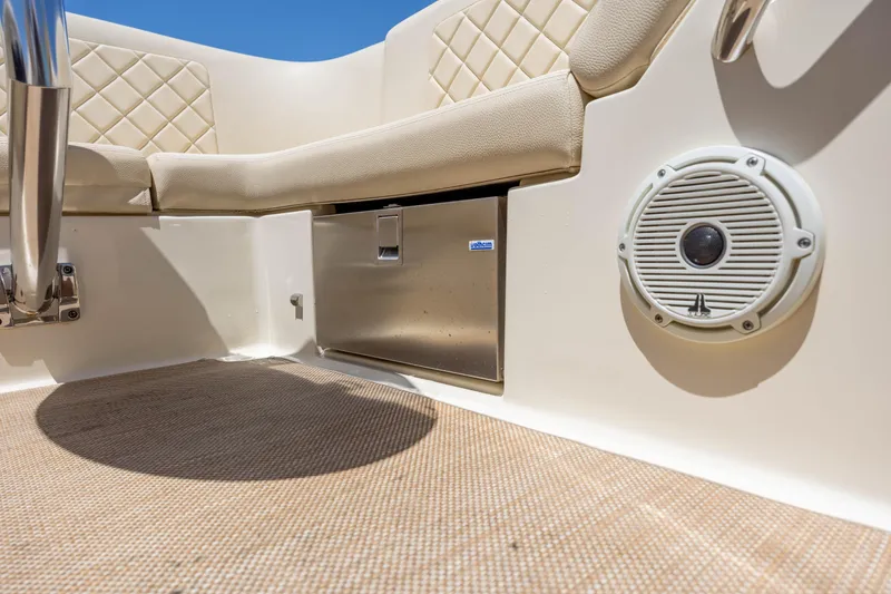 Slide: The Image of 2022 Chris-Craft Launch 27 interior with beige seating, speaker, and stainless steel compartment. - 23