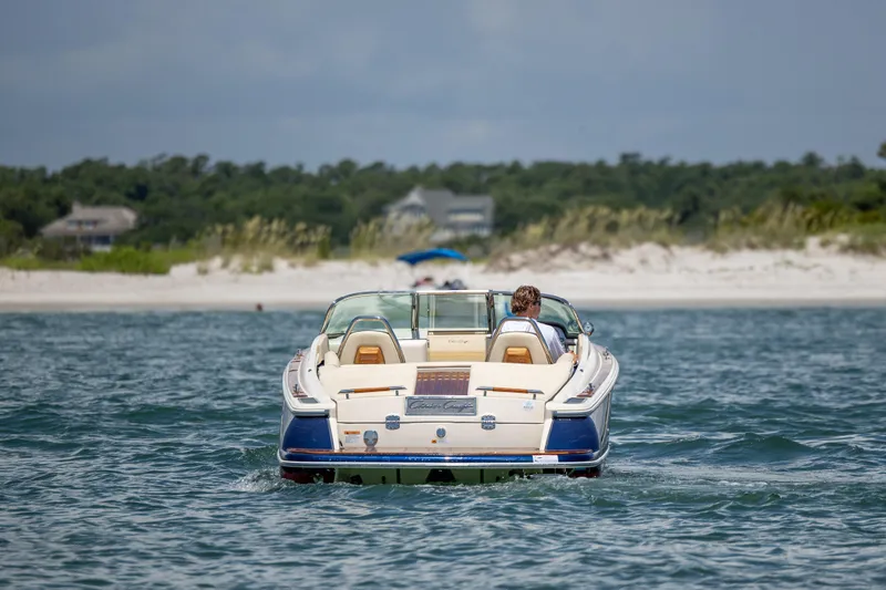 Slide: The Image of 2022 Chris-Craft Launch 27 boat cruising near a sandy beach. - 3
