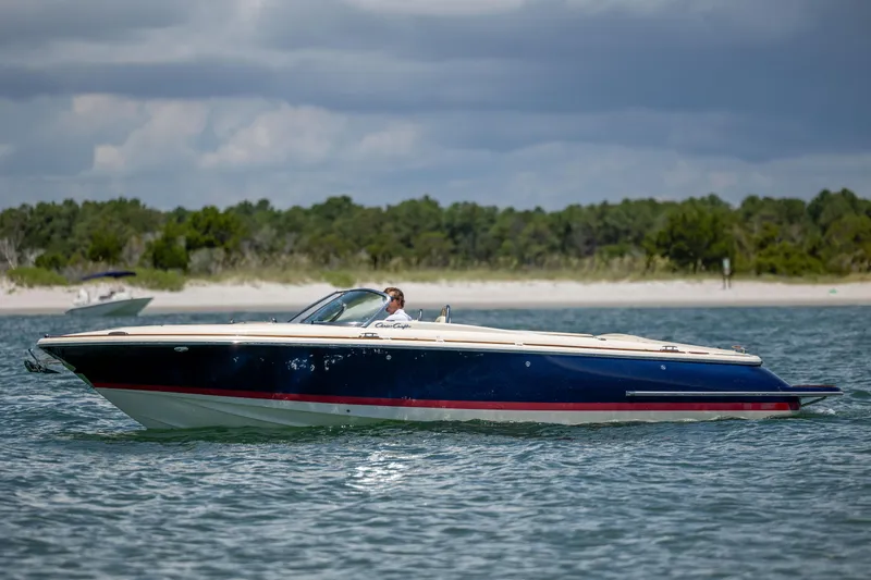 Slide: The Image of 2022 Chris-Craft Launch 27 boat cruising on a scenic waterway. - 9