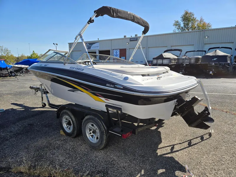 Slide: The Image of 2007 Four Winns 200 Horizon boat on trailer, parked outdoors near a building. - 4