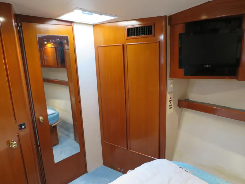 Slide: The Image of 1997 Post 50 Flybridge yacht interior with wooden cabinets and mounted TV. - 11