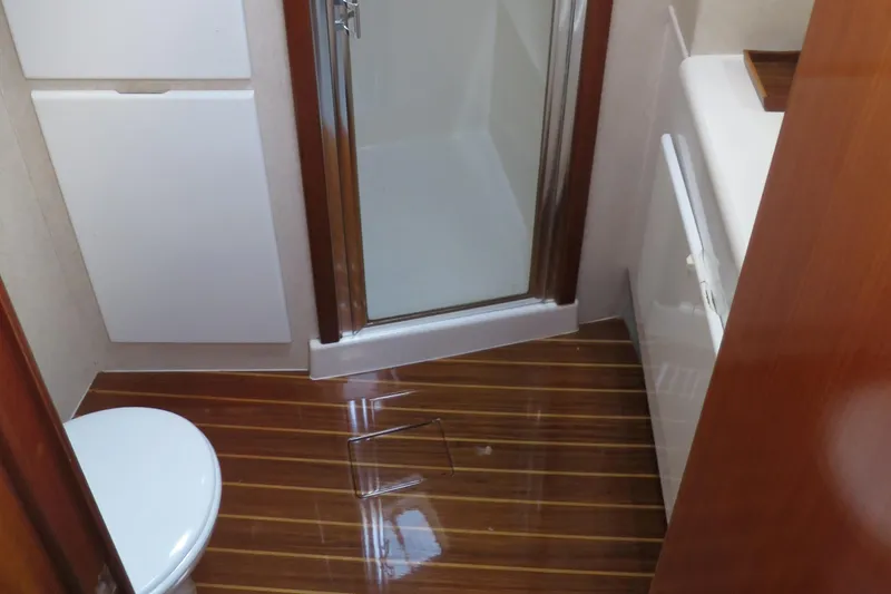 Slide: The Image of 1997 Post 50 Flybridge bathroom with shower, toilet, and wooden flooring. - 15
