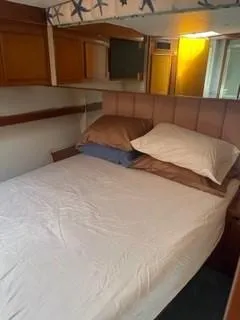 Slide: The Image of 1997 Post 50 Flybridge cabin with bed and wooden storage cabinets. - 8