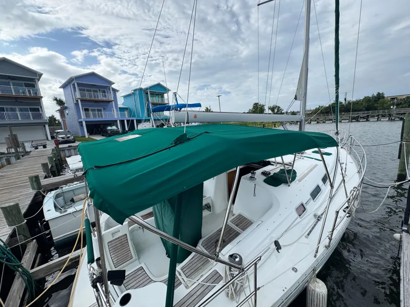 Slide: The Image of 2005 Beneteau Oceanis Clipper 373 sailboat docked near colorful waterfront homes. - 2