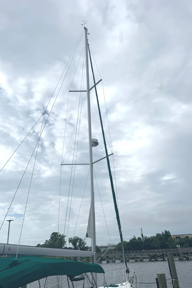 Slide: The Image of 2005 Beneteau Oceanis Clipper 373 sailboat with tall mast against cloudy sky. - 37