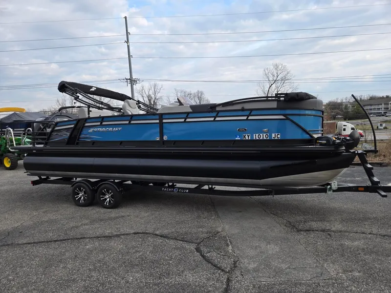 Slide: The Image of 2024 Starcraft CX25RL pontoon boat on trailer, parked outdoors. - 5