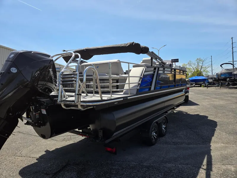 Slide: The Image of 2024 Starcraft Sls3qdh pontoon boat with Mercury outboard motor, parked on a trailer. - 4