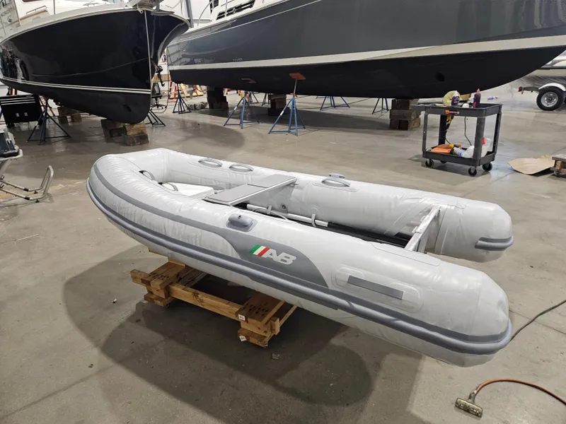 Slide: The Image of 2024 AB Inflatables 9AL boat displayed in a showroom on a wooden pallet. - 1