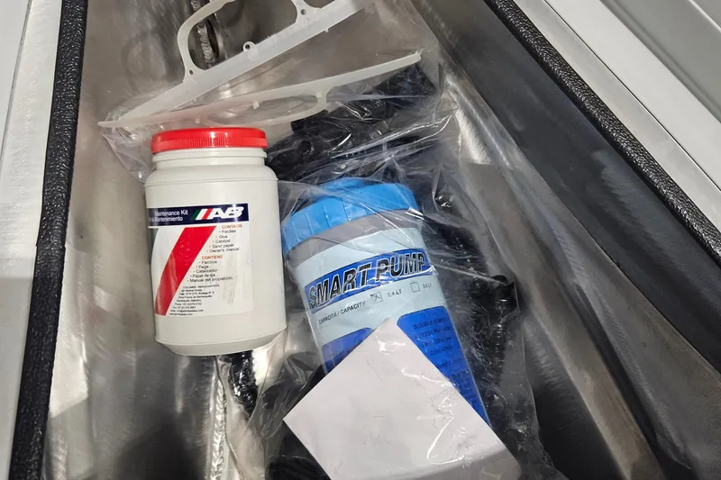 Slide: The Image of 2024 AB Inflatables 9AL maintenance kit and pump in storage compartment. - 10