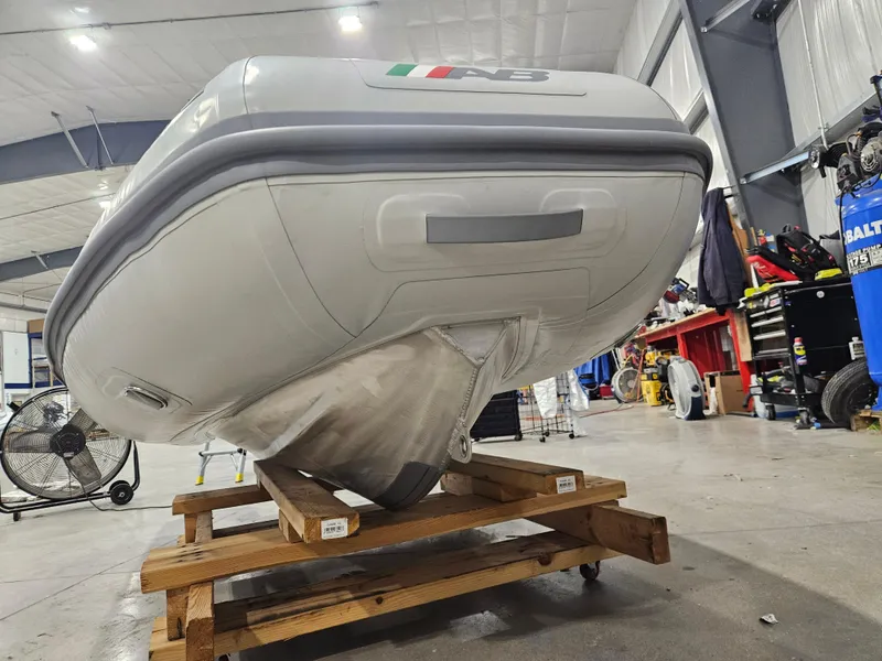 Slide: The Image of 2024 AB Inflatables 9AL boat displayed in a workshop on a wooden stand. - 4