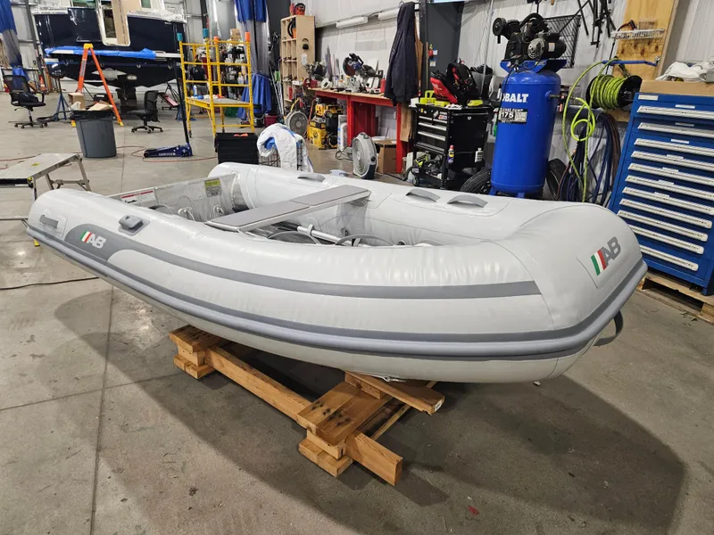 Slide: The Image of 2024 AB Inflatables 9AL boat in a workshop setting, resting on wooden pallets. - 7