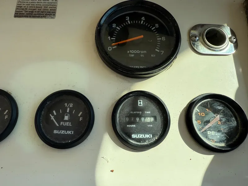 Slide: The Image of Dashboard gauges of a 1987 Parker 25 Sport Cabin boat, featuring Suzuki instruments. - 17
