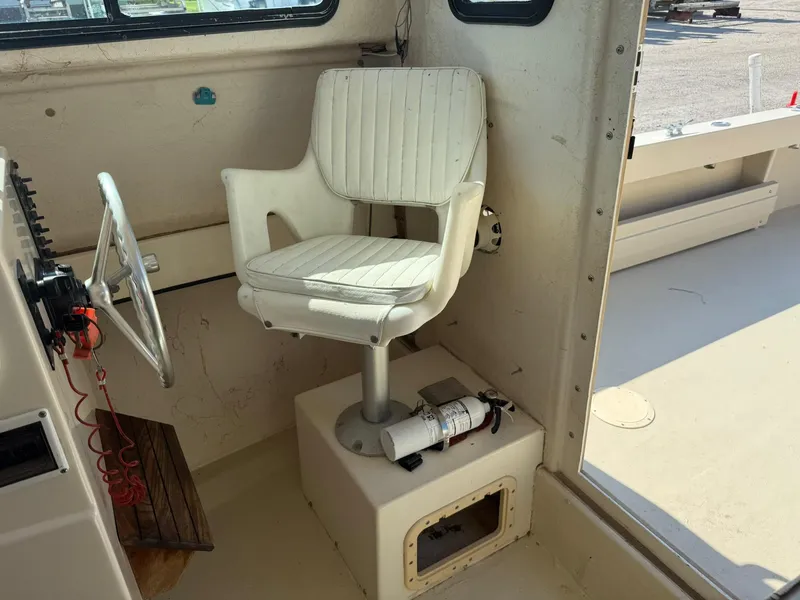 Slide: The Image of 1987 Parker 25 Sport Cabin interior with white captain's chair and steering wheel. - 18