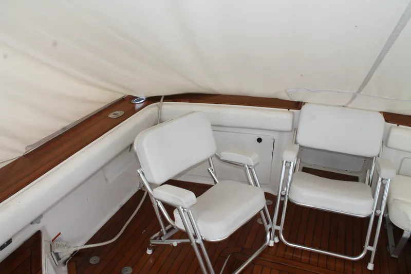 Slide: The Image of 2004 Tiara Yachts 2900 Coronet interior with white chairs and wooden flooring. - 11