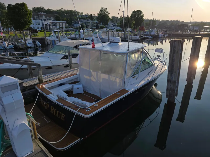 Slide: The Image of 2004 Tiara Yachts 2900 Coronet docked at a serene marina during sunset. - 2