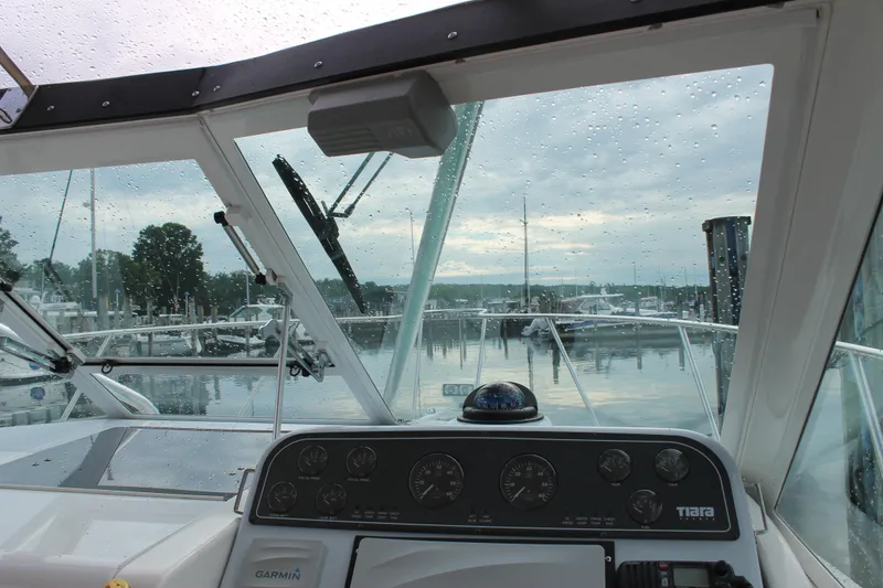 Slide: The Image of 2004 Tiara Yachts 2900 Coronet dashboard view with raindrops on windshield at marina. - 20