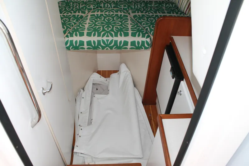 Slide: The Image of 2004 Tiara Yachts 2900 Coronet cabin interior with green patterned bedding and storage area. - 32