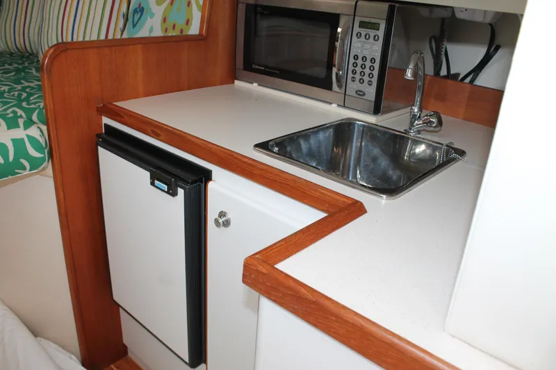 Slide: The Image of 2004 Tiara Yachts 2900 Coronet kitchenette with sink, microwave, and mini fridge. - 35