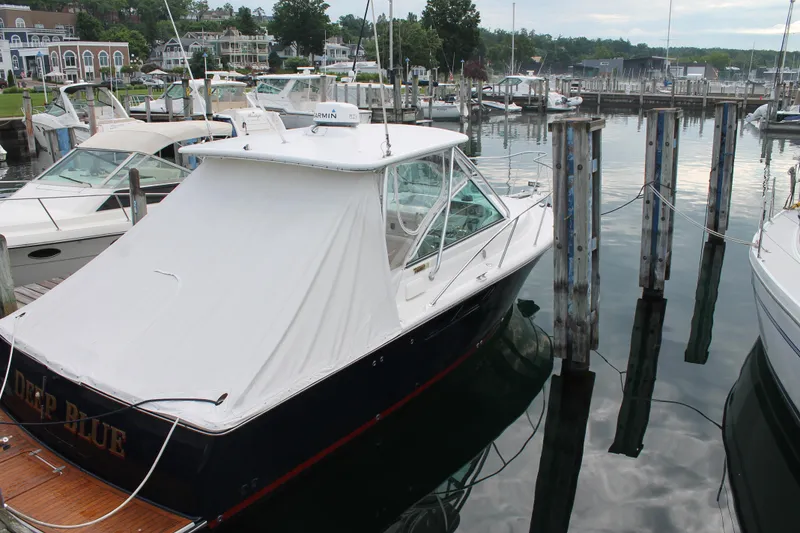 Slide: The Image of 2004 Tiara Yachts 2900 Coronet docked in a marina, covered with a white canopy. - 6