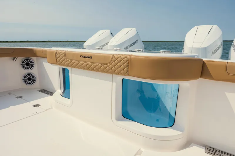 Slide: The Image of 2025 Caymas 44 CT boat interior with tan seating, blue windows, and Mercury engines. - 10