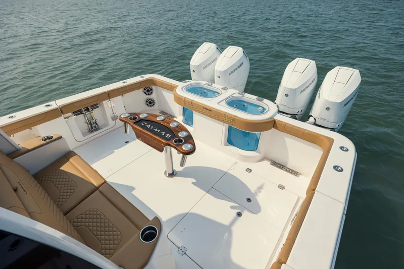 Slide: The Image of 2025 Caymas 44 CT boat deck with seating, fishing station, and four Mercury outboard engines. - 11