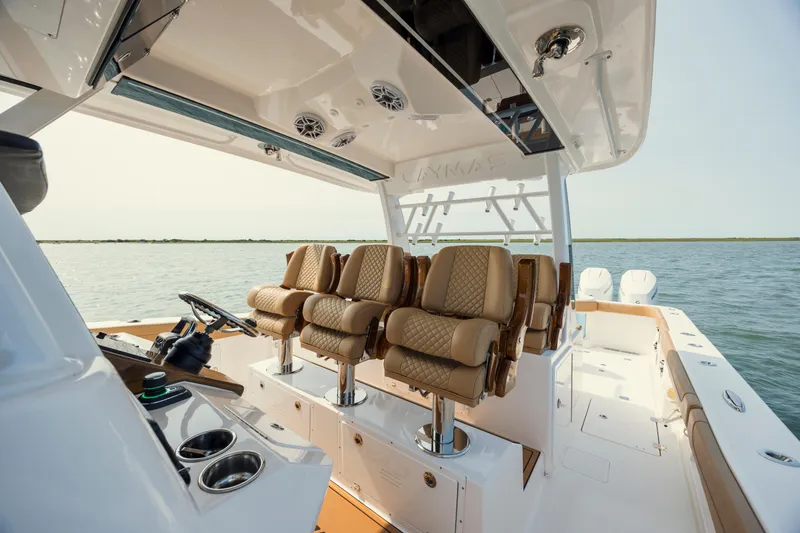 Slide: The Image of 2025 Caymas 44 CT boat interior with luxurious seating and modern helm on open water. - 18
