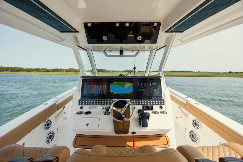 Slide: The Image of 2025 Caymas 44 CT boat cockpit with advanced navigation system on open water. - 23