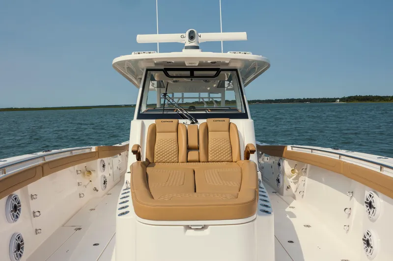 Slide: The Image of 2025 Caymas 44 CT boat with tan seating, cruising on open water. - 31
