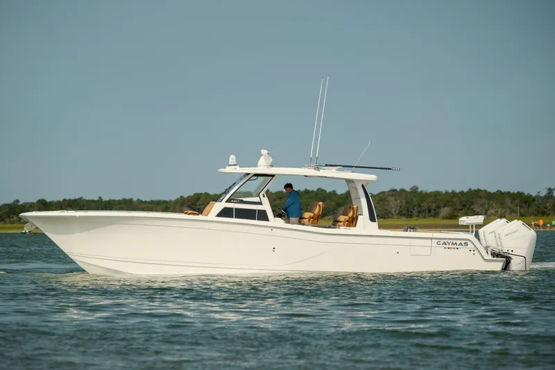 Slide: The Image of 2025 Caymas 44 CT boat cruising on a calm lake with a clear sky. - 5