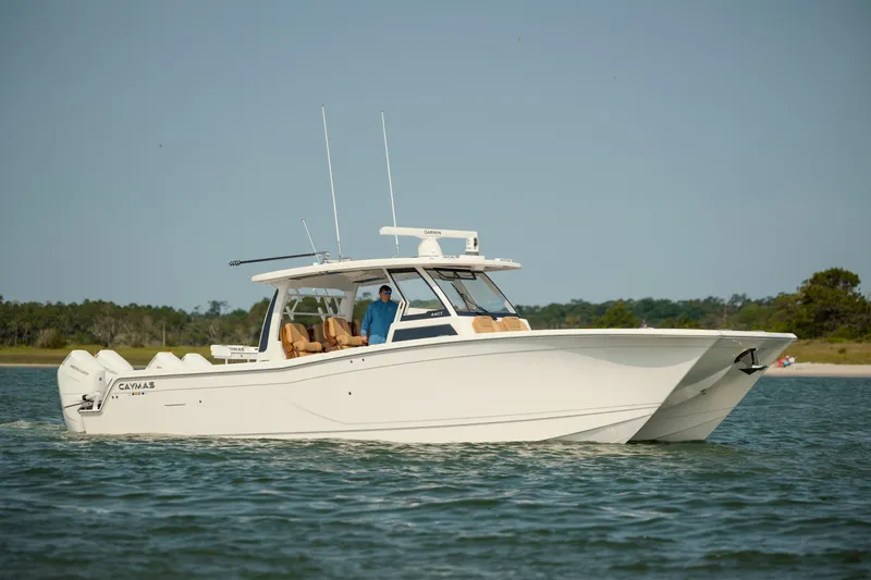Slide: The Image of 2025 Caymas 44 CT boat cruising on calm water, featuring sleek design and powerful engines. - 7