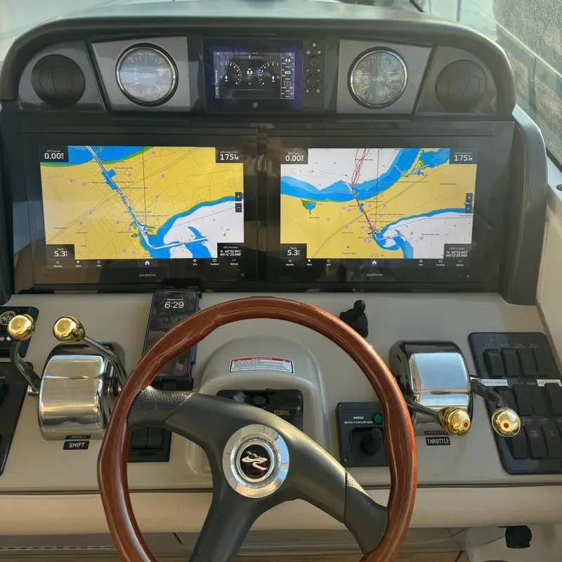 Slide: The Image of Helm of 2006 Sea Ray 48 Sundancer with dual navigation screens and wooden steering wheel. - 10