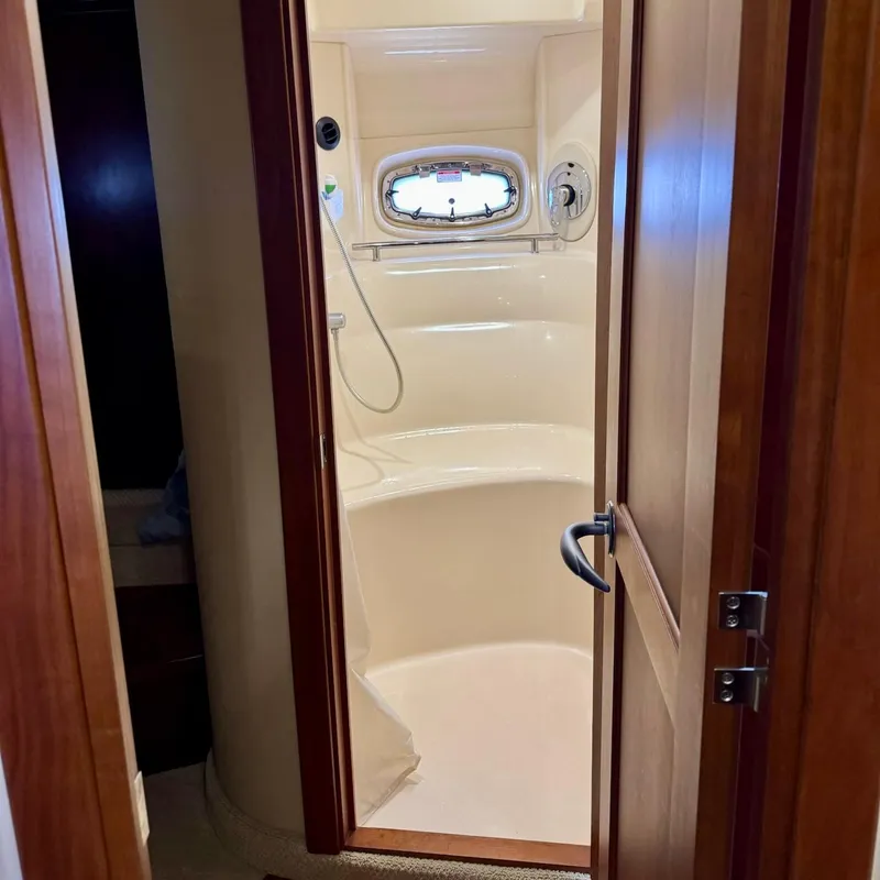 Slide: The Image of Shower area inside 2006 Sea Ray 48 Sundancer yacht, featuring a compact design and porthole window. - 28