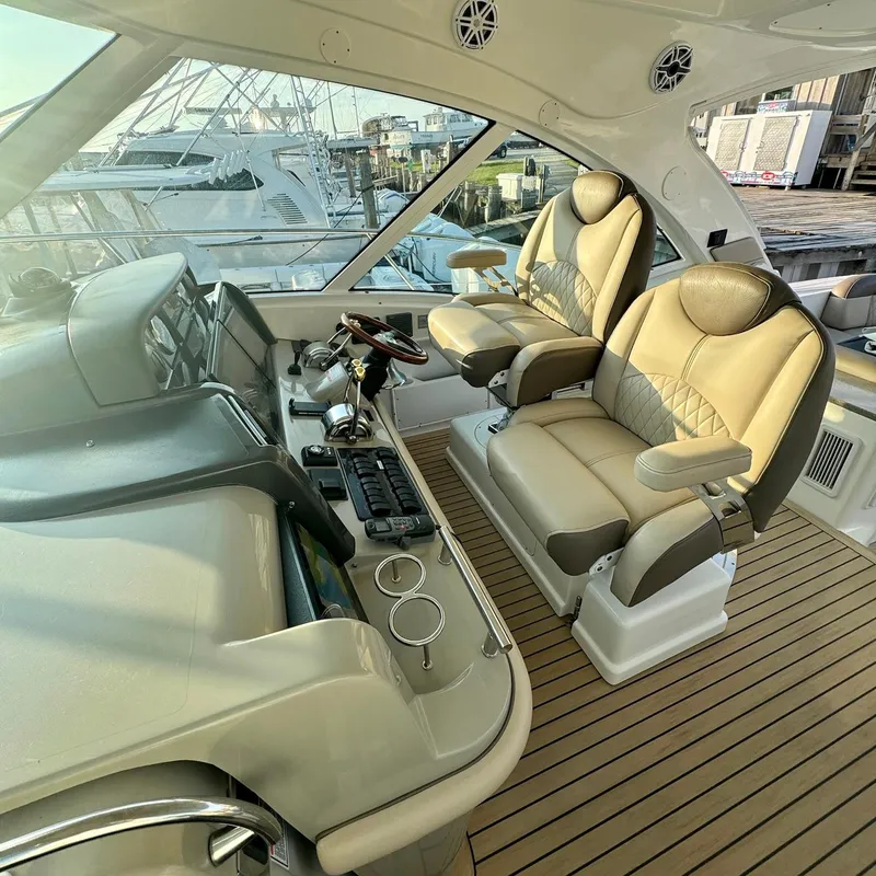 Slide: The Image of Interior of 2006 Sea Ray 48 Sundancer yacht with luxurious helm seats and control panel. - 7