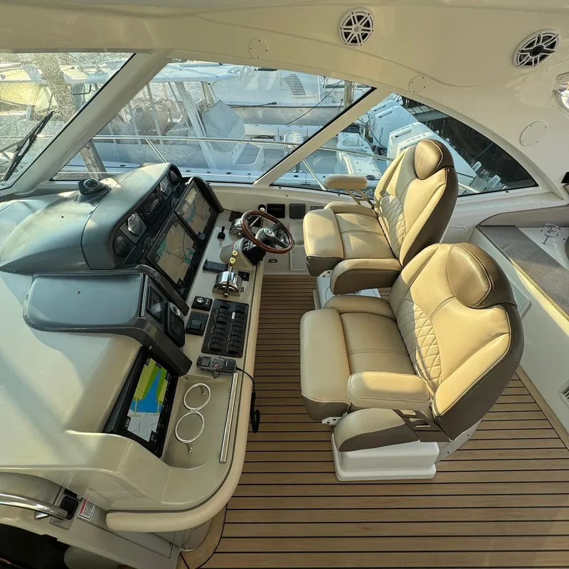 Slide: The Image of Luxurious helm of 2006 Sea Ray 48 Sundancer with dual leather seats and advanced navigation systems. - 8