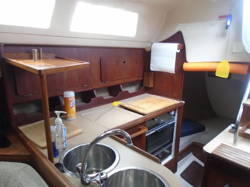Slide: The Image of Interior of 1989 Hunter 30 sailboat kitchen with sink, stove, and wooden cabinetry. - 3