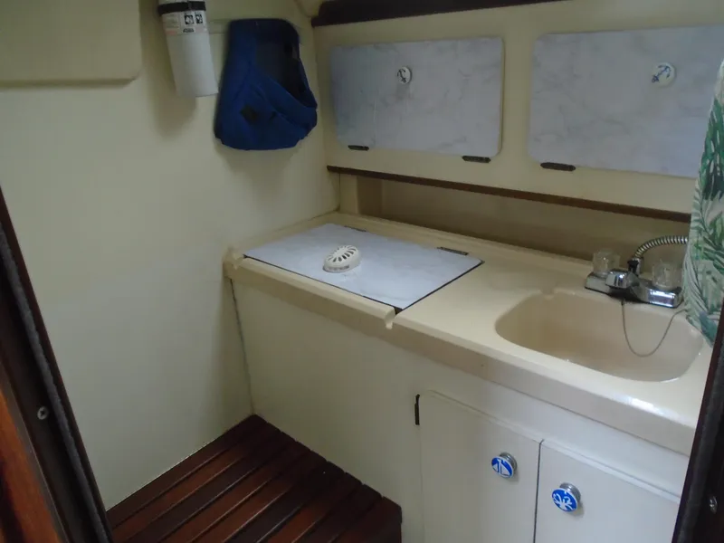 Slide: The Image of 1989 Hunter 30 sailboat galley with sink, storage, and wooden flooring. - 7