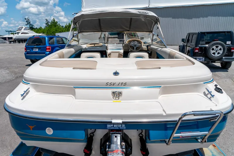 Slide: The Image of 1995 Glastron 195 SSV boat with canopy, parked outdoors on a sunny day. - 12