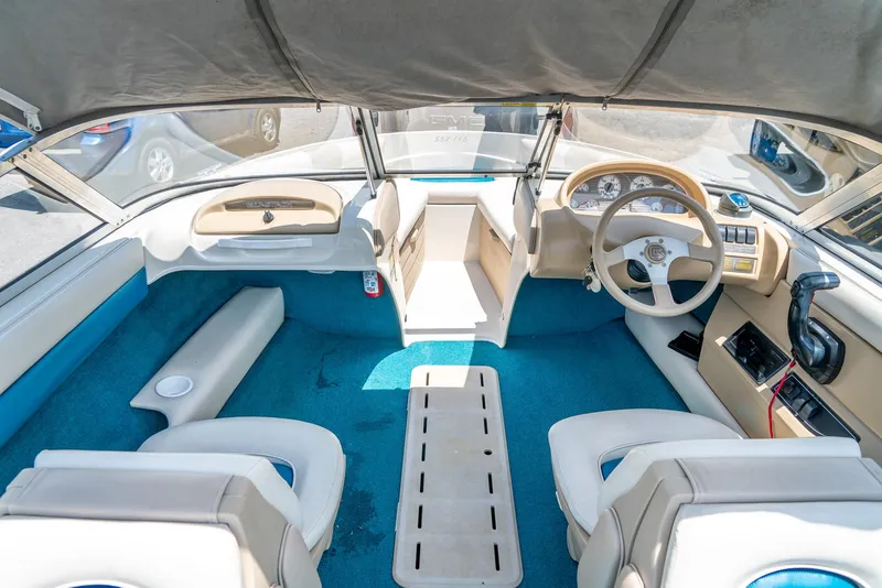 Slide: The Image of Interior of a 1995 Glastron 195 SSV boat with blue carpet and beige seating. - 16