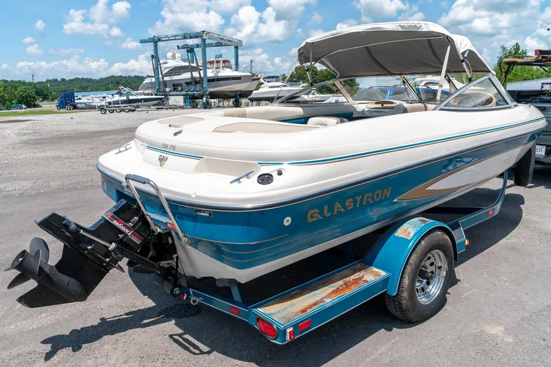 Slide: The Image of 1995 Glastron 195 SSV boat on trailer, blue and white, parked outdoors. - 4