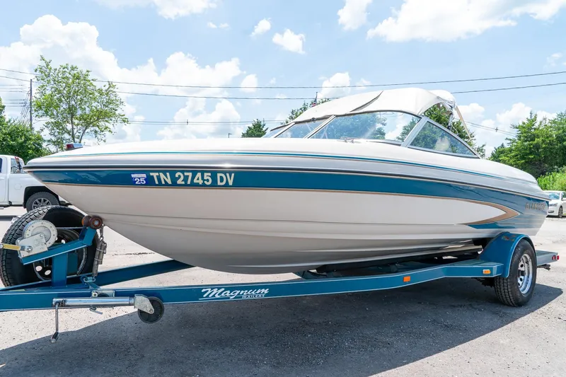 Slide: The Image of 1995 Glastron 195 SSV boat on trailer, parked outdoors under a clear sky. - 6