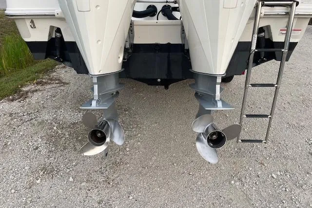 Slide: The Image of Twin propellers of a 2022 Boston Whaler 25' Outrage boat on gravel. - 10